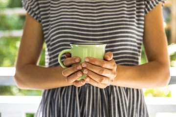 Frau, die eine Tasse hält Frau, die eine Tasse hält